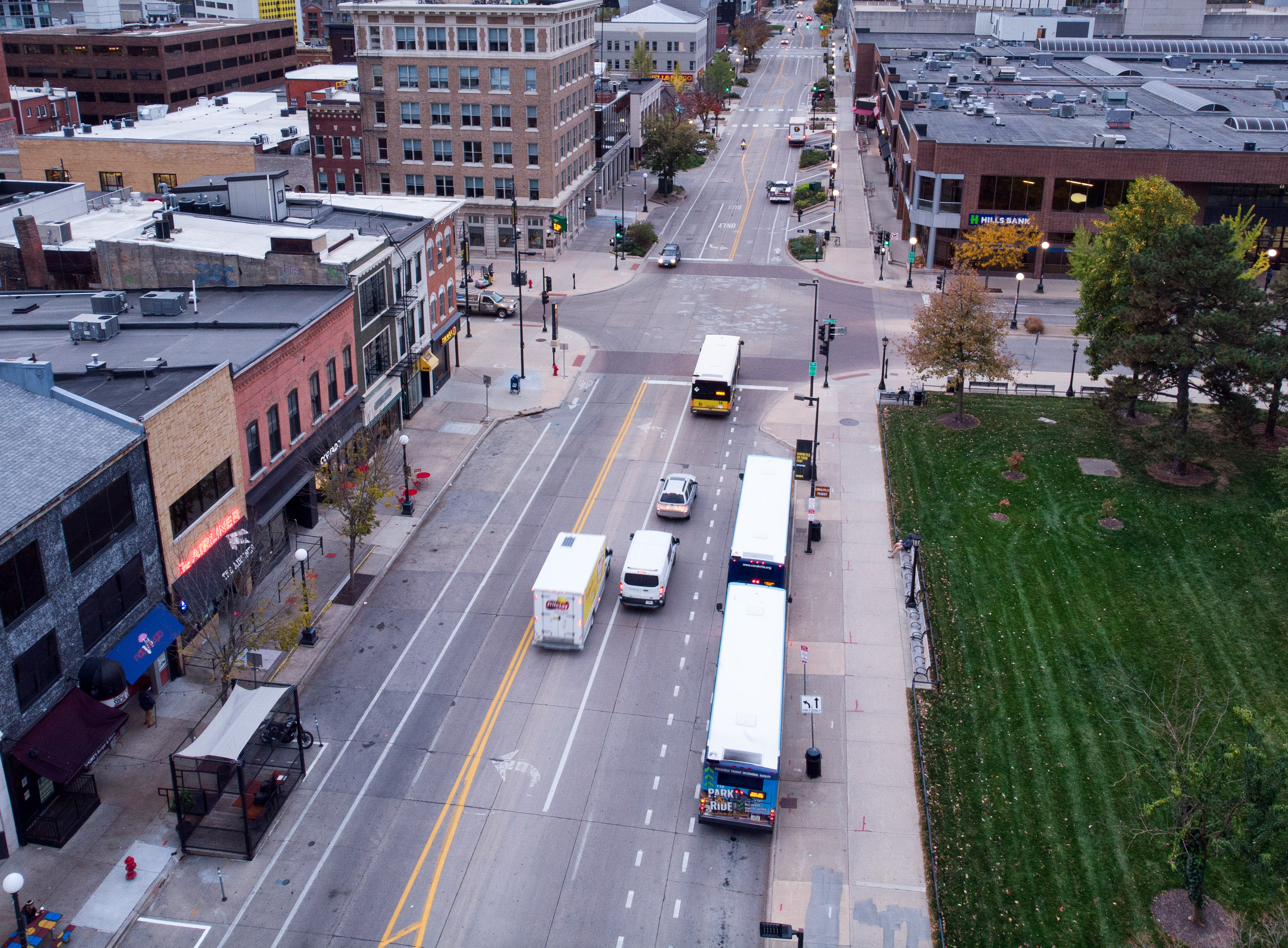 multiple city and university buses travel near Pentacrest image right and downtown image left