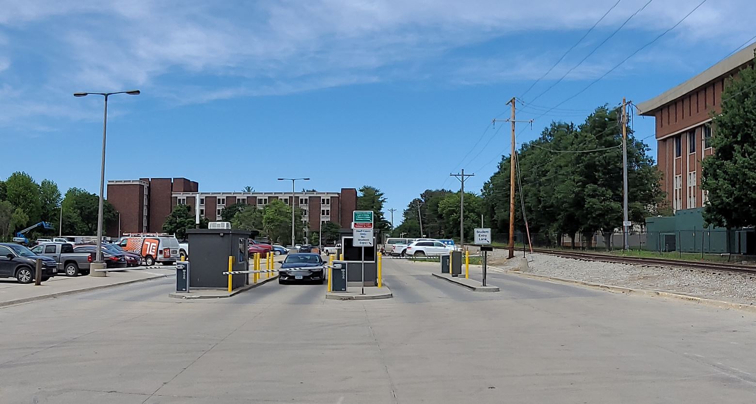 Surface parking lot with two entry lanes and two exit lane on sunny partly cloudy summer day