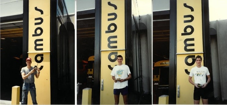 there photos of a person standing in front of yellow door holding trophy