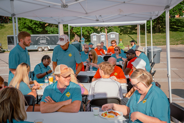 Attendees enjoy a picnic lunch under a tent at the IPTA state bus roadeo