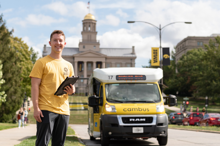 Driver standing with bionic bus in front of old capitol building