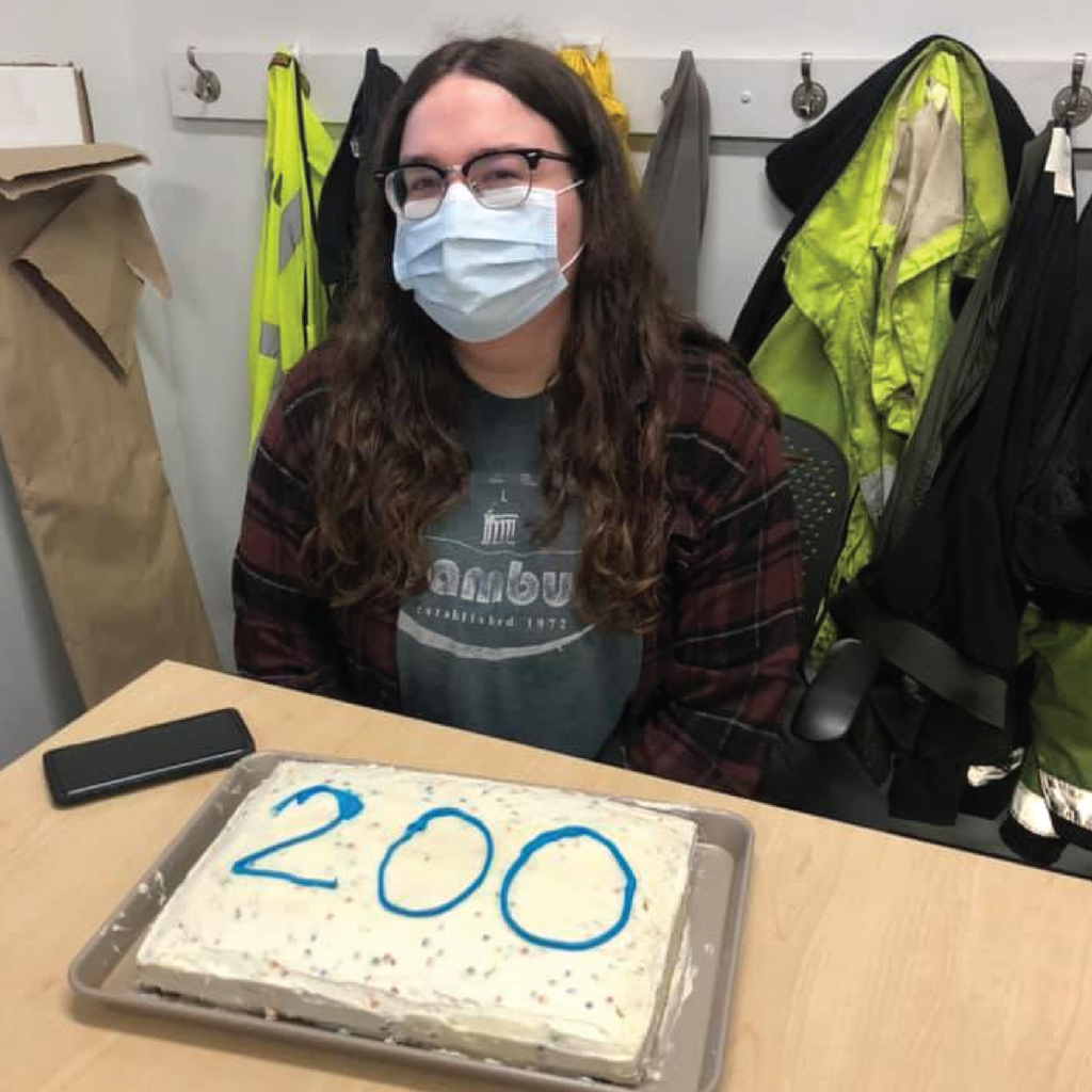 Charlie sits at a table with a cake that reads 200