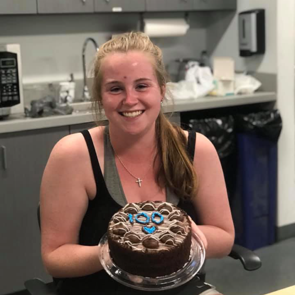 employee Michaela Messier poses with a cake