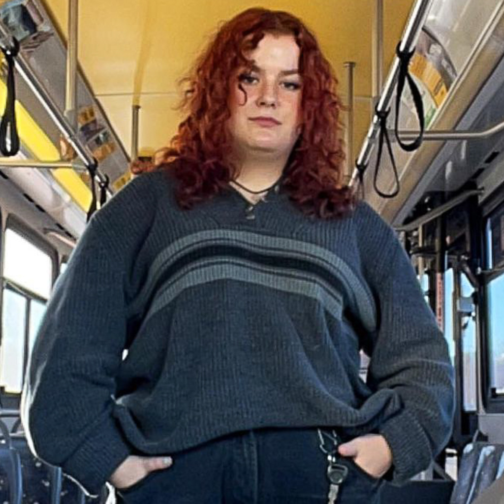 CAMBUS student driver Michaela Davis poses on a bus.