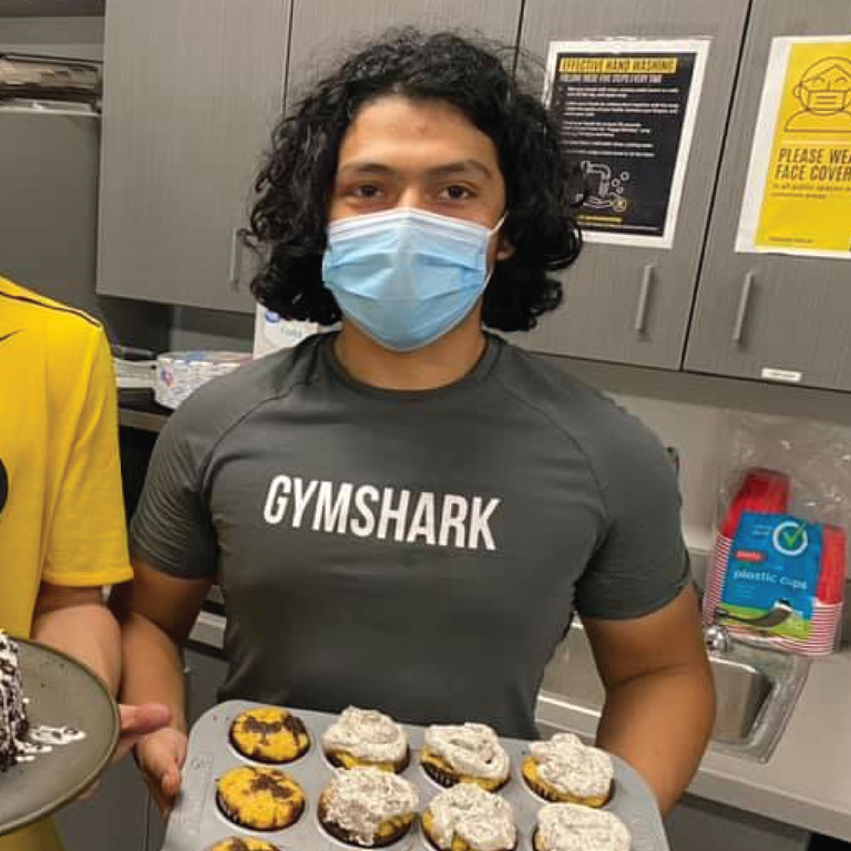 Jace holds cupcakes in the maintenance facility break room