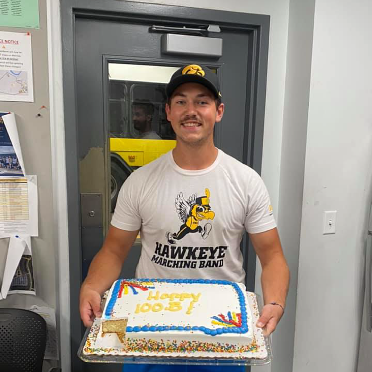 employee Jarrett West poses for photo with a cake