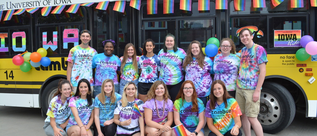 group of CAMBUS employees wearing pride shirts posing for a photo in front a CAMBUS