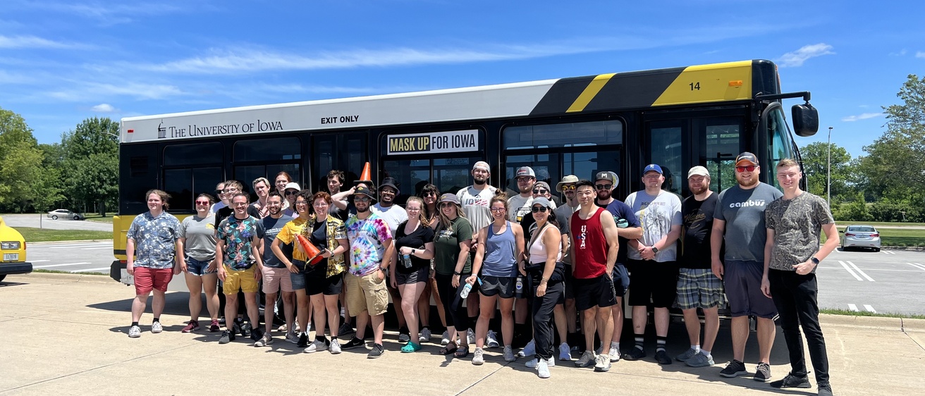 Group of CAMBUS student employees pose in front of a bus