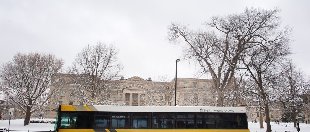 black and gold bus travels on road in snowy conditions