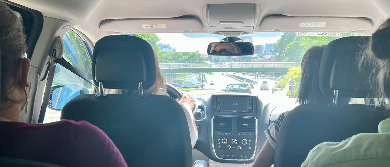 An image showing the interior of a van and its driver. 