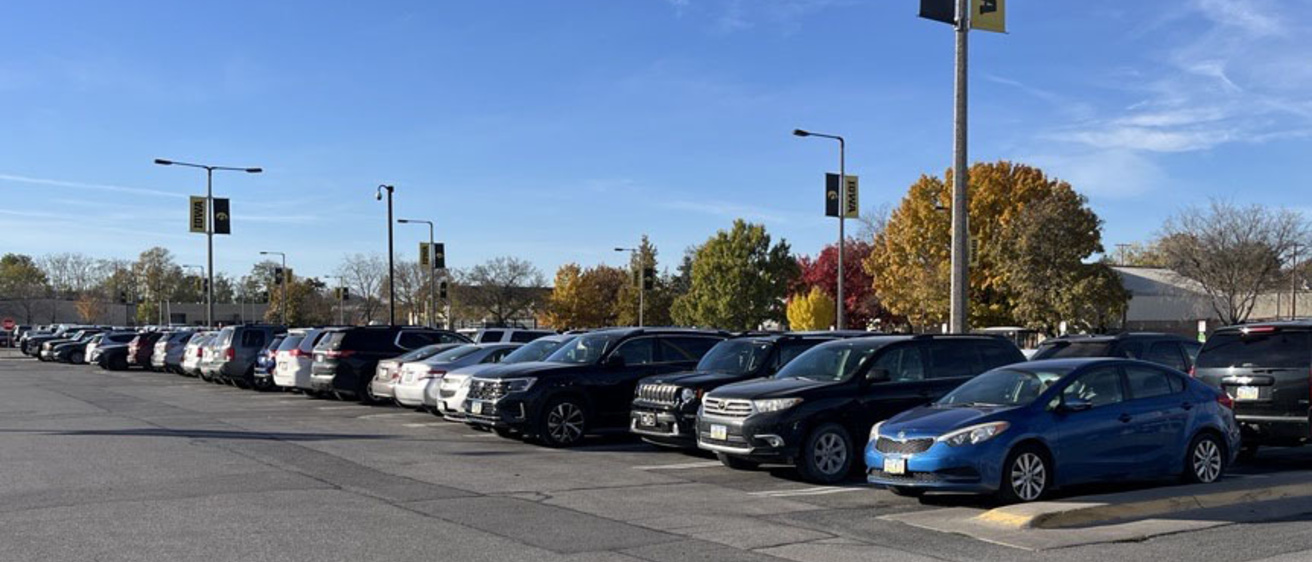 parking lot with vehicles parked in rows with University of Iowa logos on light poles