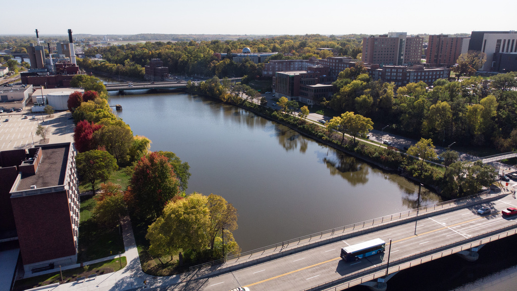 buses, cars, and pedestrians crossing over river on bridge