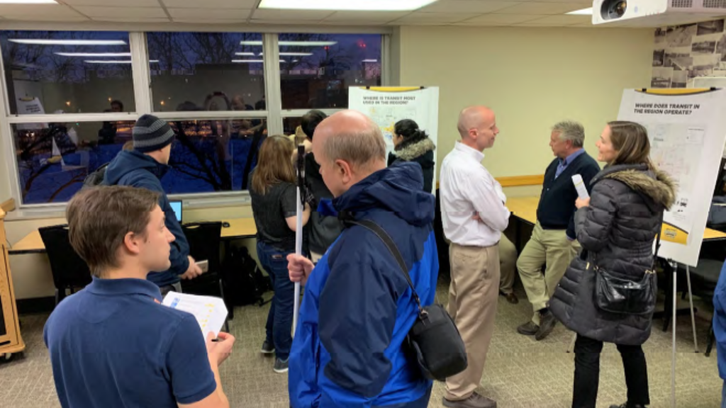 attendees gather at an open house meeting for the transit study