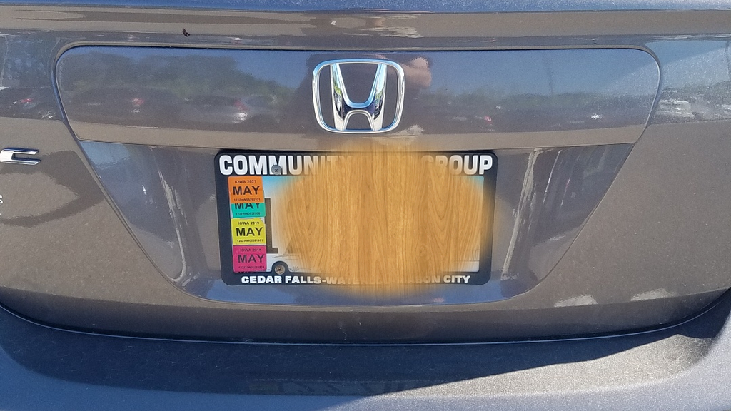 image of license plate with stickers blocking part of the plate