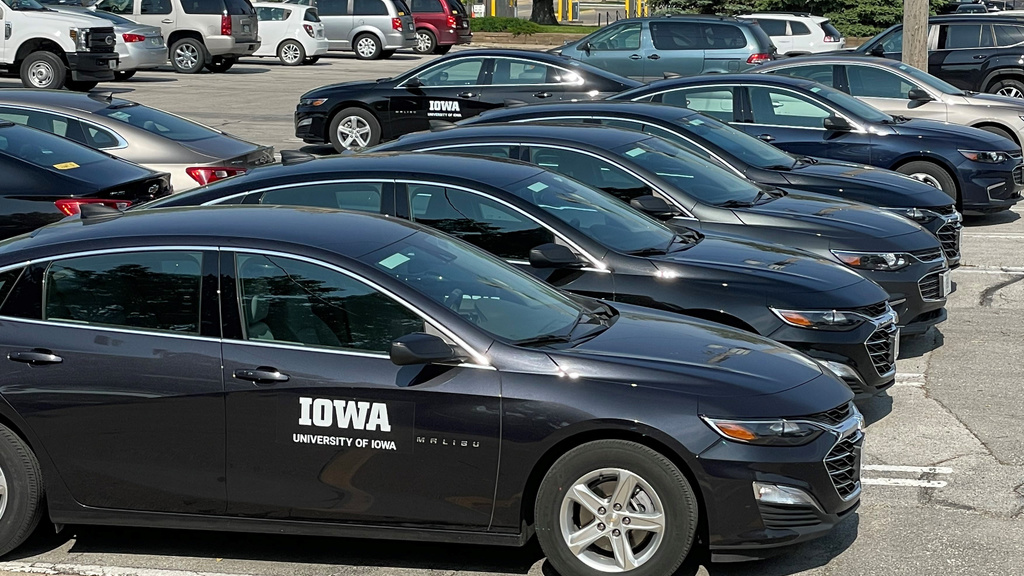 Black sedan cards in a row with white "Iowa, University of Iowa" decal on door