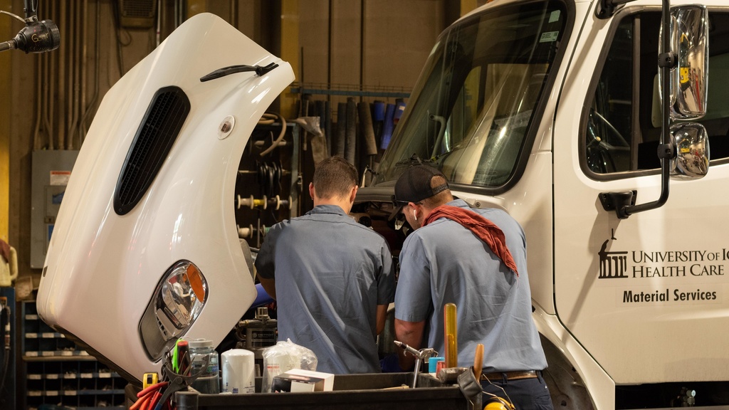 technicians Robert Bousek and Jamie Watson perform maintenance on a large truck