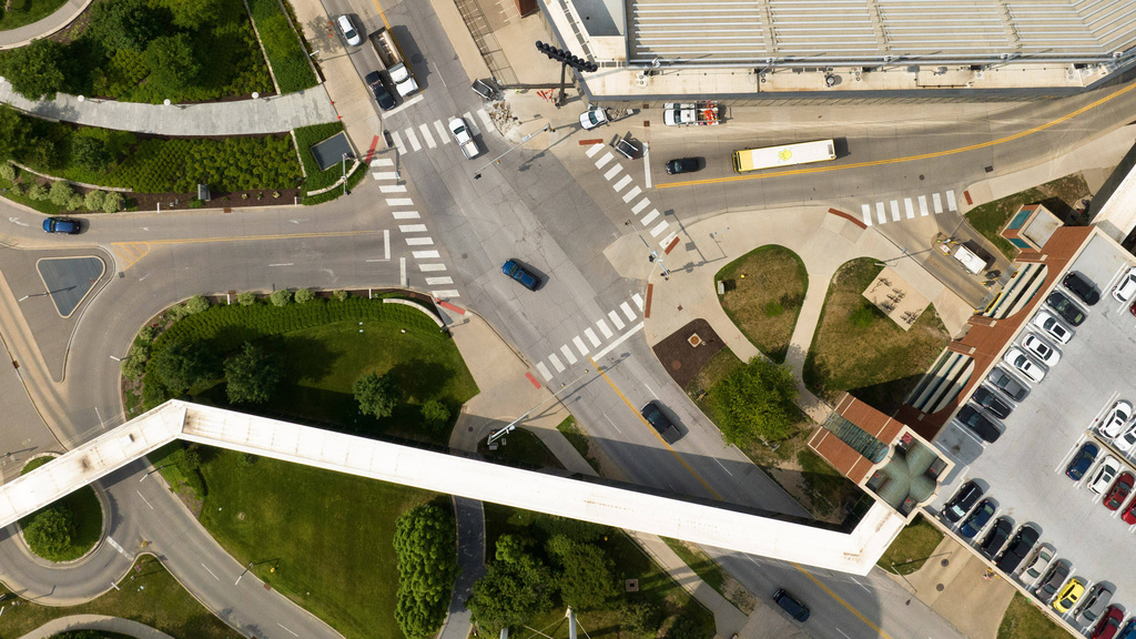 image from drone showing intersection, skyway, parking ramp roof, and traffic