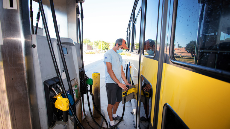 CAMBUS employee filling up bus with gas