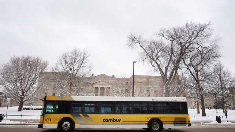 black and gold bus travels on road in snowy conditions